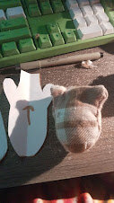 a brown plaid dogthing head with ears as part of the cut pieces rather than being sewn in afterward, posed next to the cutout i did for the top of its head
